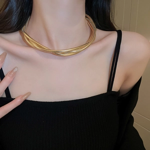 Detail of twisted multi-layer snake bone necklace in gold and silver mixed metallic tones