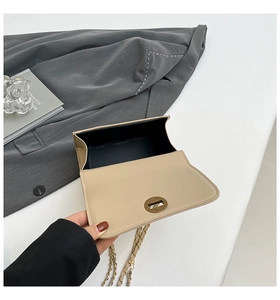 Detail view of the beige chain bag showing interior lining and golden twist lock