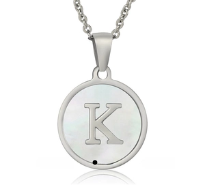 Macro shot of stainless steel round pendant with shell inlay and silver letter K