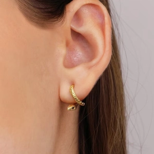 Macro detail of gold snake stud earring featuring intricate scale texture on sterling silver