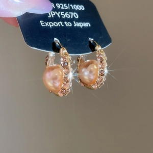 Close-up of 925 silver U-shaped hoop earring with pink pearl and zircon accents
