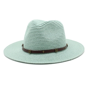 Detailed straw weave texture on mint green sun hat with studded brown leather band