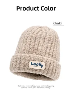 Detailed view of khaki chunky knit beanie featuring a stitched Lucky letter label