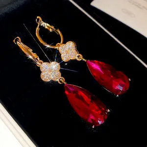 Sparkling clover earrings with teardrop ruby pendants in a premium black gift box