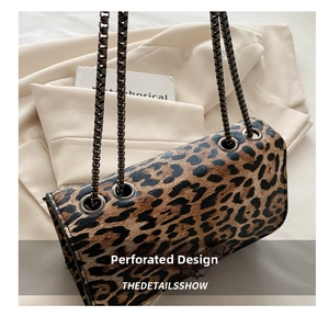 Detail of leopard print shoulder bag featuring metal chain straps and trendy leopard pattern