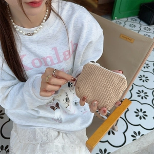 Gros plan sur la trousse à cosmétiques beige en tissu gaufré pour accessoires