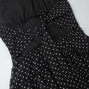 Detailed view of the black polka dot dress featuring an open back and bow-tie detail