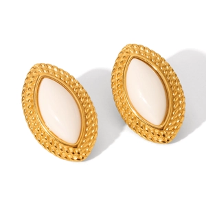 Detailed macro view of vintage gold stainless steel earrings with milky resin inlays