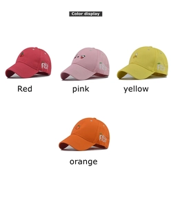 Detailed embroidery view of cherry and fruit patterns on colorful cotton baseball caps