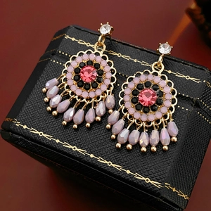 Detail of vintage gold earrings with pink and black crystals and lavender drop beads