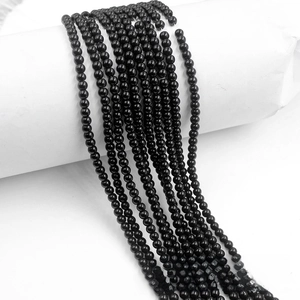 Close-up of polished black glass beads with mirror-like finish for DIY jewelry making