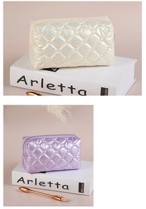Close-up of quilted down-filled cosmetic bags in white and purple with glossy finish