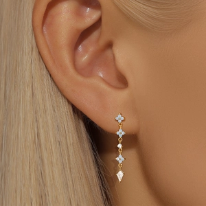Elegant gold drop earrings with blue petals and rhombus crystals on female model
