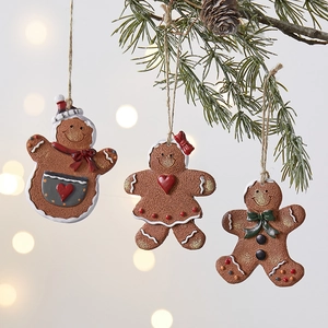 Set of 3 festive resin gingerbread man ornaments hanging on a Christmas tree branch