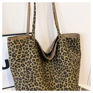 Detail of leopard print canvas tote bag showing the textured fabric and large shoulder strap