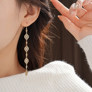 Detail shot of vintage gold tassel drop earrings with hollow flower and leaf motifs