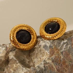 Détail de boucles d'oreilles vintage avec texture martelée et incrustation de grès bleu