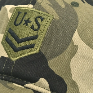 Gros plan sur la broderie militaire et le logo étoile de la casquette camouflage