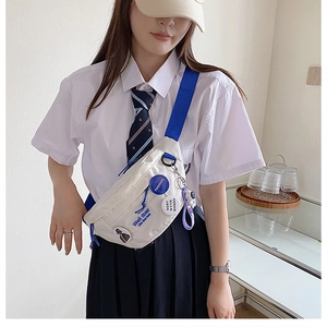 Detail of off-white canvas chest bag with blue strap and trendy patches in street style