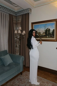 Detail of elegant white high-neck maxi dress with long sleeves and cutout waist feature