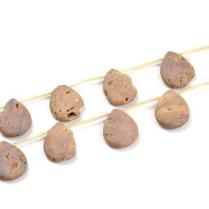 Macro detail of natural teardrop-shaped yellow stone beads with raw crystal texture