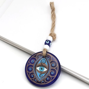 Close-up of blue glass evil eye pendant with hemp rope and decorative blue beads