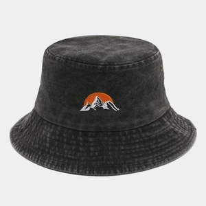 Detail showing the sun and mountain embroidery on dark grey washed bucket hat