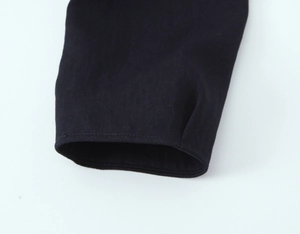 Detail shot of black twill fabric blazer cuff with precision stitching and fine texture
