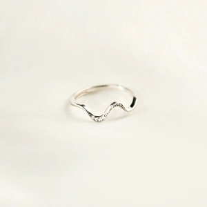 Detailed view of s925 sterling silver wave ring with micro-set zircons on white fabric