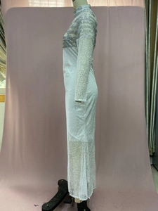 Detail of white maxi dress featuring silver sequins and intricate lace patterns on mesh