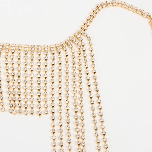 Close-up of gold tassel head chain with clear rhinestones on a white background