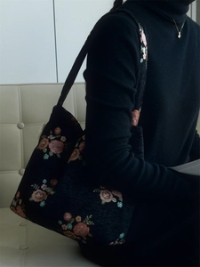 Detail of floral embroidery and woven jacquard texture on a vintage shoulder bag