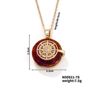 Detail view of a gold-plated sunburst pendant with gradient stone and size dimensions