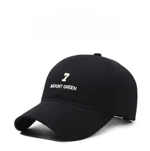 Close-up of white 7 Mount Green embroidery on a black washed cotton baseball cap