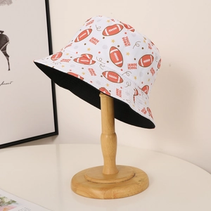 Reversible bucket hat with American football print and black lining on wooden stand