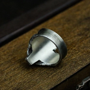 Retro gothic skull coffin ring for men with vintage brushed silver finish on dark wood