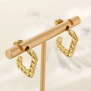 Detail of gold chain link hoop earrings displayed on a professional T-bar stand