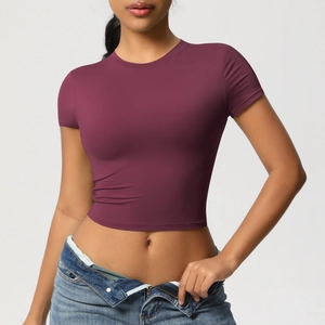 Detail view of burgundy tight-fitting yoga crop top paired with stylish blue denim jeans