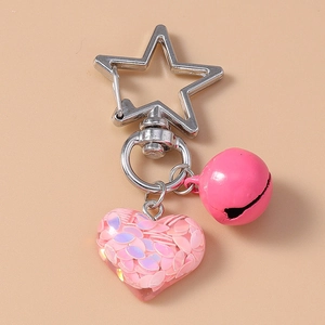 Detailed macro view of pink heart sequin pendant with silver star clasp and bell