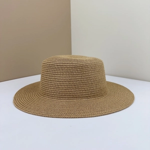 Detail of a brown woven flat top boater straw hat with fine texture and spiral weave