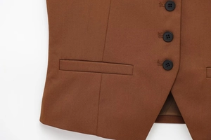 Détail du gilet en sergé marron avec trois boutons noirs et couture de la poche latérale