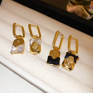 Detail of vintage lion head earrings with rectangular crystal in gold-plated finish
