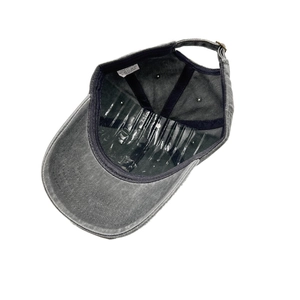 Detail view of washed grey cotton baseball cap interior with adjustable strap and care label