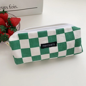 Detail of green and white checkerboard canvas pouch with merciparis woven label