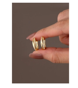 Detail shot of gold-plated S925 silver earrings with pavé zircon and S925 hallmark