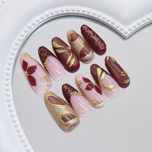 Retro leopard and floral press-on nails with gold 3D accents on heart mirror tray