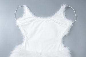 Close-up detail of white bodycon dress featuring elegant faux fur trim along the neckline