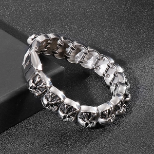 Detailed close-up of retro skull links on a punk style stainless steel men's bracelet