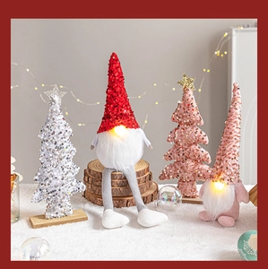 Close-up of glowing nose Christmas gnomes and sequin trees on cozy white carpet