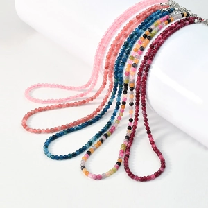 Detailed view of colorful beaded necklaces with silver lobster clasps on white stands